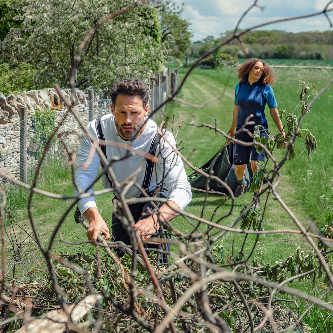 Man cutting down plants wearing the Genus Gardening Braces