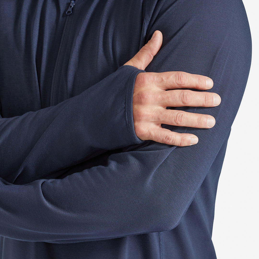 Man showing the thumb hole on a Genus Men's Marine Blue Eden Zip Neck Top 
