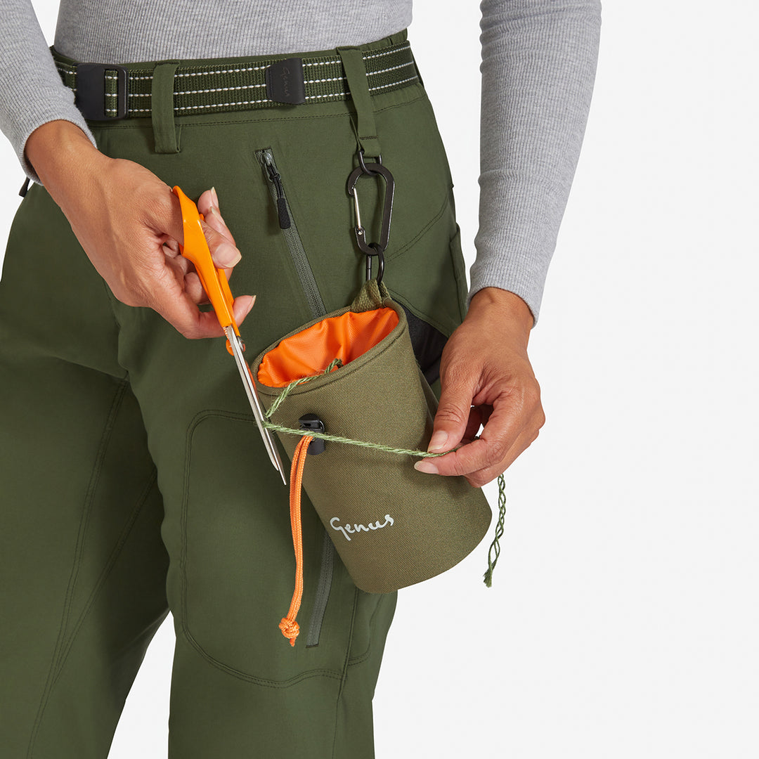 Woman clipping a small bag onto the Genus Women's New Green Waterproof Trousers